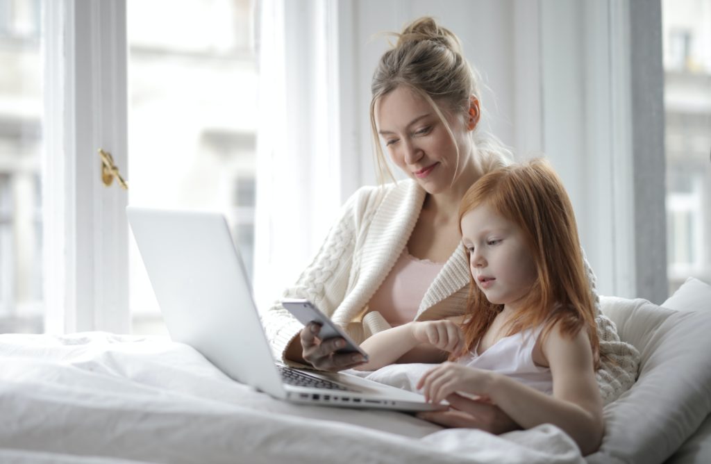Mom with daughter on computer and phone