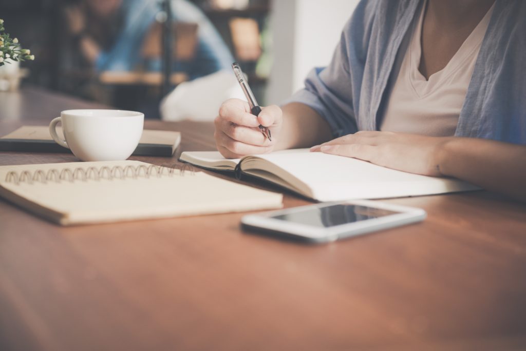 person taking notes on a desk